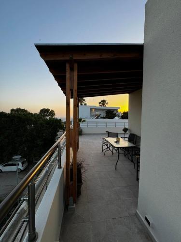 a balcony with a table and a view of the ocean at Andreas Studios in Mastichari