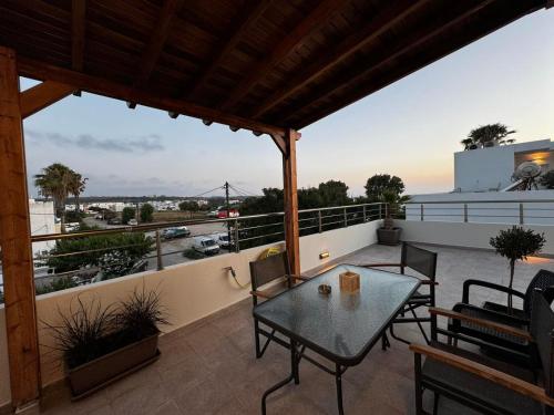 a patio with a table and chairs on a balcony at Andreas Studios in Mastichari
