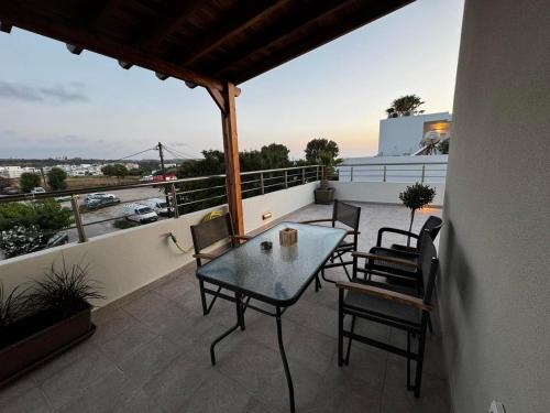 a patio with a table and chairs on a balcony at Andreas Studios in Mastichari