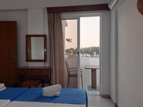 a bedroom with a bed and a view of a balcony at Annabel Apartments in Theologos