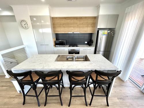 a kitchen with a table with four chairs around it at Casa De Praia - Entire Home - North Beach in Wallaroo