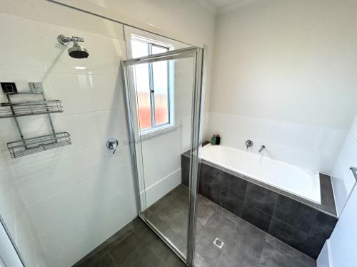 a bathroom with a shower and a bath tub at Casa De Praia - Entire Home - North Beach in Wallaroo