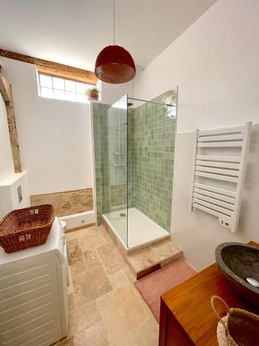 une salle de bain avec douche et lavabo dans l'établissement Grange rénovée, jardin privé et piscine partagée, à Poussan