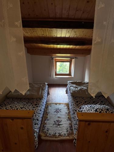 an attic room with two beds and a window at Gites de Gobertier in Saint-Alban-dʼAy