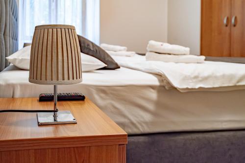 a lamp on a table next to two beds at Relax Hotel Stork in Lednice