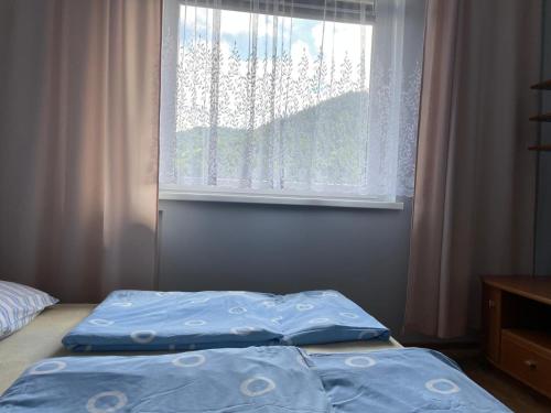 a bedroom with two beds in front of a window at Szczawnica - Pokoje z widokiem na góry in Szczawnica