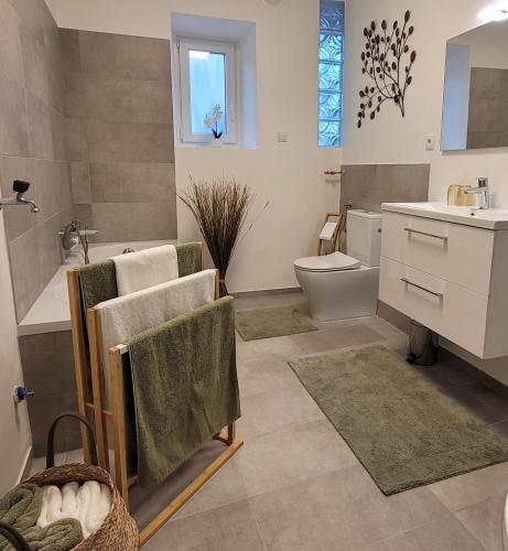 a bathroom with a sink and a toilet and a tub at Casa Melina in Mörbisch am See