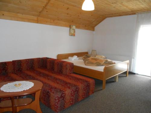 a living room with a couch and a bed at Magdalenka - pokoje w centrum in Szczyrk
