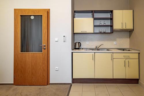 a kitchen with white cabinets and a door at Relax Hotel Stork in Lednice