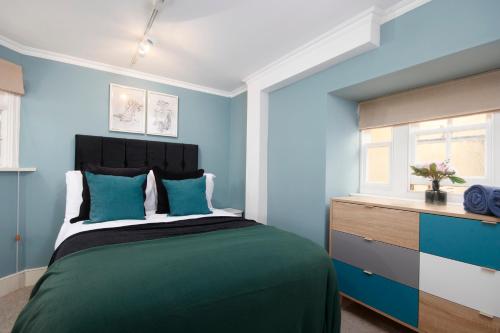 a bedroom with a bed with blue walls and a window at Beautiful 2 Bedroom 3 actual beds House with WiFi by PureStay in Bath