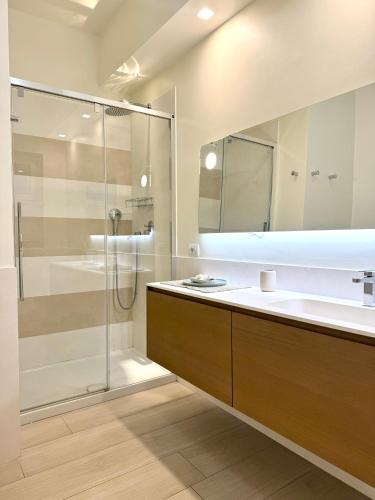 a bathroom with a glass shower and a sink at Starhost - CASA BONNIE, large furnished balcony on the Cathedral and a stone's throw from seafront, beach and ferry's pier in Minori