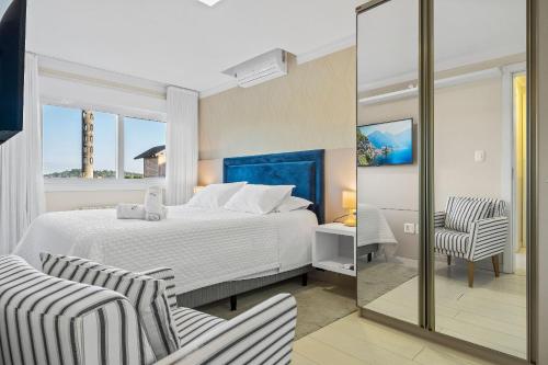 a hotel room with a bed and a chair at Catedral de Pedra Plaza 2 dorm by Achei in Canela