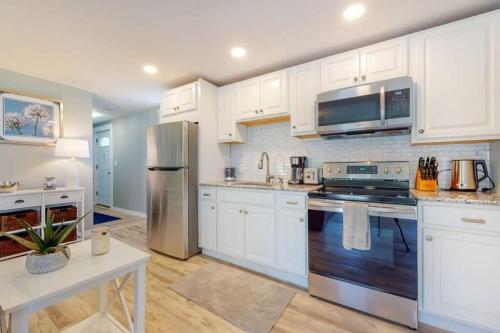 a kitchen with white cabinets and a stainless steel refrigerator at Cozy Waterfall BnB - Close To Mountains and Hikes in East Durham