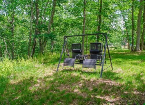 two chairs on a swing set in the woods at Cozy Waterfall BnB - Close To Mountains and Hikes in East Durham