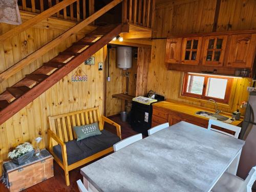 une cuisine et une salle à manger avec une table dans une cabine dans l'établissement Cabañas en Los Reartes Córdoba, à Villa General Belgrano