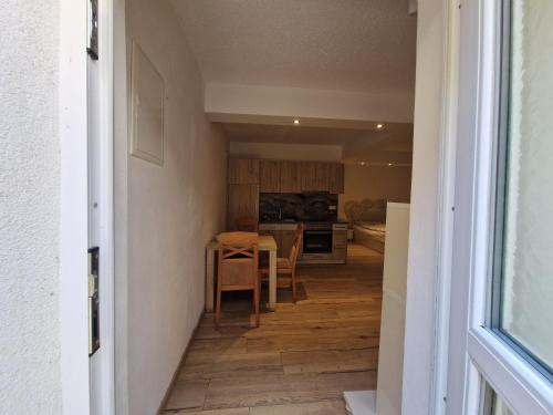 un corridoio che conduce a una cucina con tavolo e sedie di Triple Serenity Suite a Stockerau