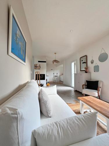 un salon avec un canapé blanc et une table dans l'établissement Maison les Flots dot Fr, à Denneville