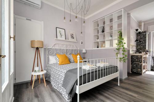 a white bedroom with a bed and a lamp at Maison Saporiti in Vigevano