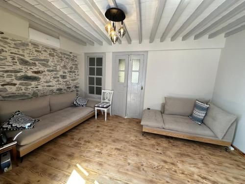 a living room with a couch and a chair at Plomari Nomad House in Plomarion