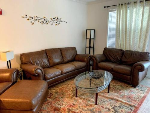 a living room with leather couches and a coffee table at Rehoboth Beach Home that has It All in Rehoboth Beach