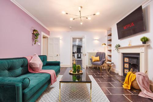 a living room with a green couch and a fireplace at Beautiful 2 Bedroom 3 actual beds House with WiFi by PureStay in Bath