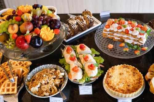 a table topped with lots of different types of food at Hotel Sete Ilhas in Florianópolis