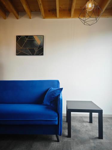 a blue couch and a table in a room at Vėjų kraštas in Svencelė