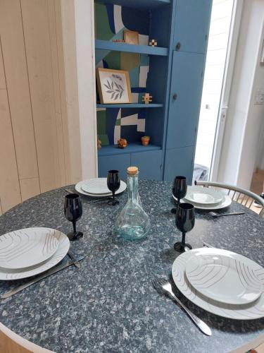 une table avec des assiettes blanches et un vase en verre dans l'établissement Le Chanzy, à Cholet