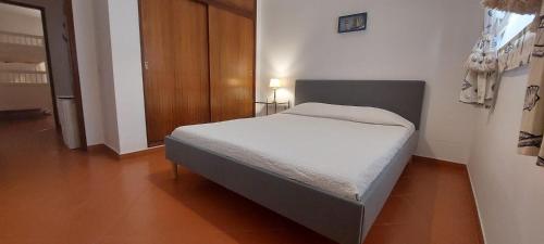 a small bedroom with a bed in a room at Cezimbra Guest House in Sesimbra