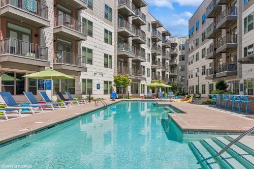 a swimming pool in a apartment complex with chairs at Kasa Noda Charlotte in Charlotte