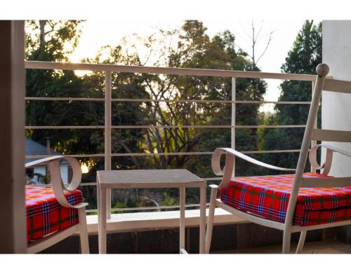 a pair of chairs and a table on a balcony at Tobriana in Nairobi