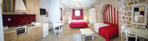 a kitchen with a red couch and a red chair at Myral Guesthouse in Nafplio