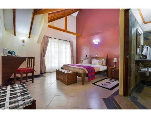 a bedroom with a bed and a desk in a room at Tobriana in Nairobi
