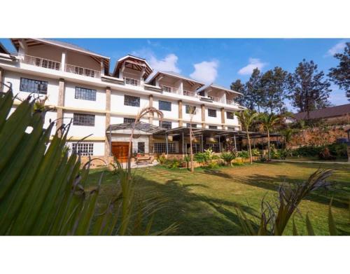 a large white building with a lawn in front of it at Tobriana in Nairobi