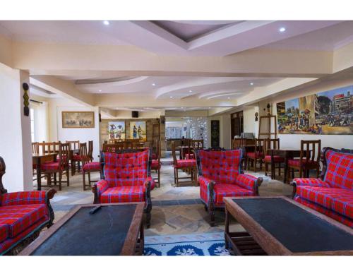 a living room with red chairs and tables and tablesktop at Tobriana in Nairobi