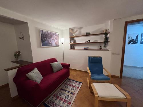 a living room with a red couch and a blue chair at Lucy house in Ronciglione