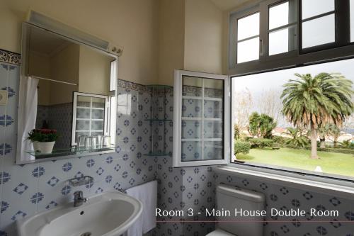 a bathroom with a sink and a window at Solar de Lalém in Maia