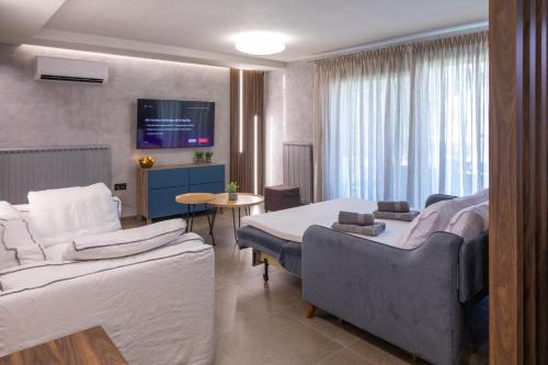 una habitación de hotel con dos camas y un sofá en ILIOS Luxury Apartment, en Nea Iraklitsa