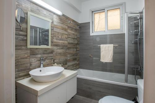 a bathroom with a white sink and a shower at Neapolis Residence Spacious Quiet Near beach in Limassol