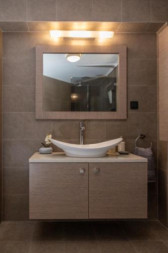 a bathroom with a sink and a mirror at ILIOS Luxury Apartment in Iraklitsa