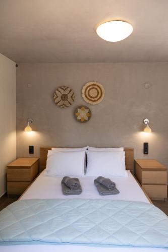 a bedroom with a white bed with two towels on it at ILIOS Luxury Apartment in Iraklitsa