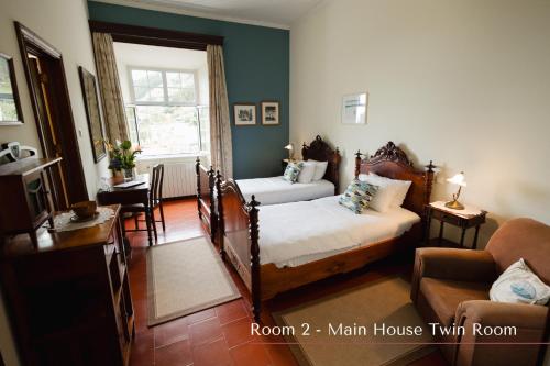 a bedroom with two beds and a living room with a couch at Solar de Lalém in Maia