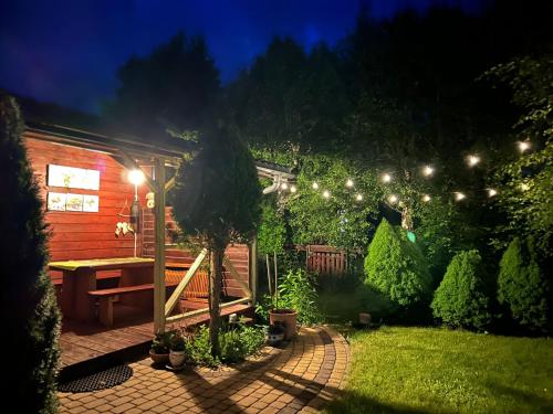 een tuin met een bank en verlichting bij Leśny Domek in Kopalino