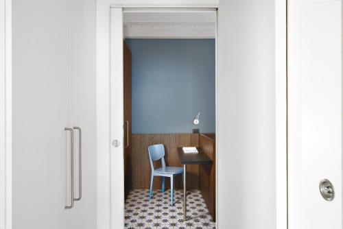 a door leading into a room with a chair and a desk at Appartamenti Caffè Maya in Maslianico