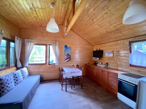 een kamer met een keuken en een tafel in een hut bij Leśny Domek in Kopalino