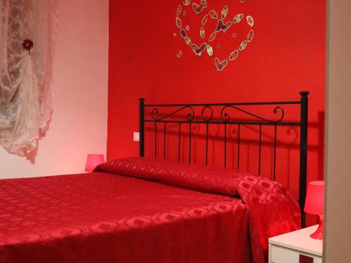 a bedroom with red walls and a bed with a red bedspread at B&B Il Viale in Alba Adriatica
