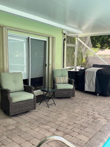 a screened in porch with chairs and a table at BLD Vacation Residences in West Palm Beach