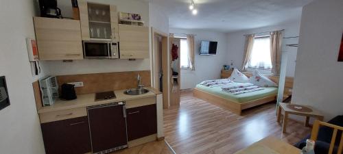a small apartment with a kitchen and a bed in a room at Landhaus Müller in Neustift im Stubaital