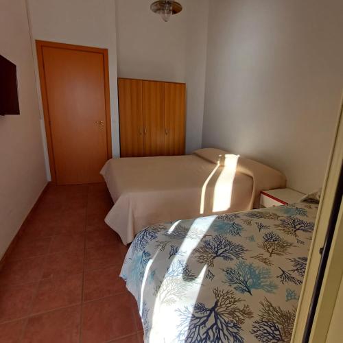 a small room with two beds and a door at Ionio in Reggio Calabria