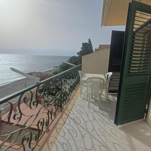 a balcony with a table and chairs and the ocean at Ionio in Reggio Calabria